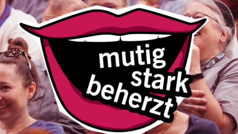 Das Foto zeigt im Hintergrund lachende Menschen. Über dem Bild liegt comicartig eine geöffneter Mund mit roten Lippen. Im Mund stehen die Worte "mutig stark beherzt".
