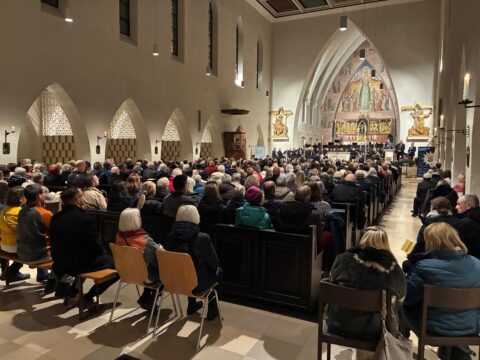 Das Foto zeigt den Innenraum der Gelöbniskirche Maria Schutz in Kaiserslautern. Alle Plätze sind mit Konzertbesuchern gefüllt.